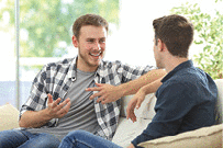 Two friends  sitting on a couch in the living room talking