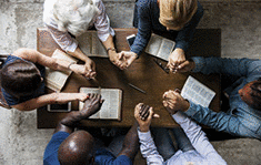 A group of people holding hands and praying