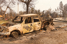 Charred truck in front of home burned to the ground in the recent wild fire storm in Redding, California.