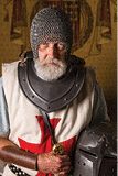 Authentic knight in medieval crusader outfit with helmet, chainmail and sword