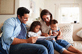 oung Hispanic family reading a book together