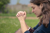 A young woman is praying and worshiping in the evening.