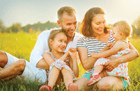 Mom, Dad and kids are laughing and hugging, enjoying nature outside!