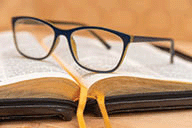 Glasses laying on a Bible