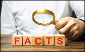 Man examines the blocks with word facts with a magnifying glass.