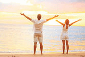 A happy cheering couple enjoying sunset at beach.