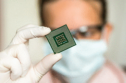 a scientist looking at a computer CPU chip
