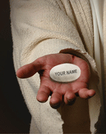 A man holding a white stone with "your name" on it.